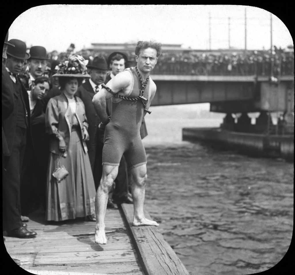 Harry Houdini performing an escape act in a vintage photograph.
